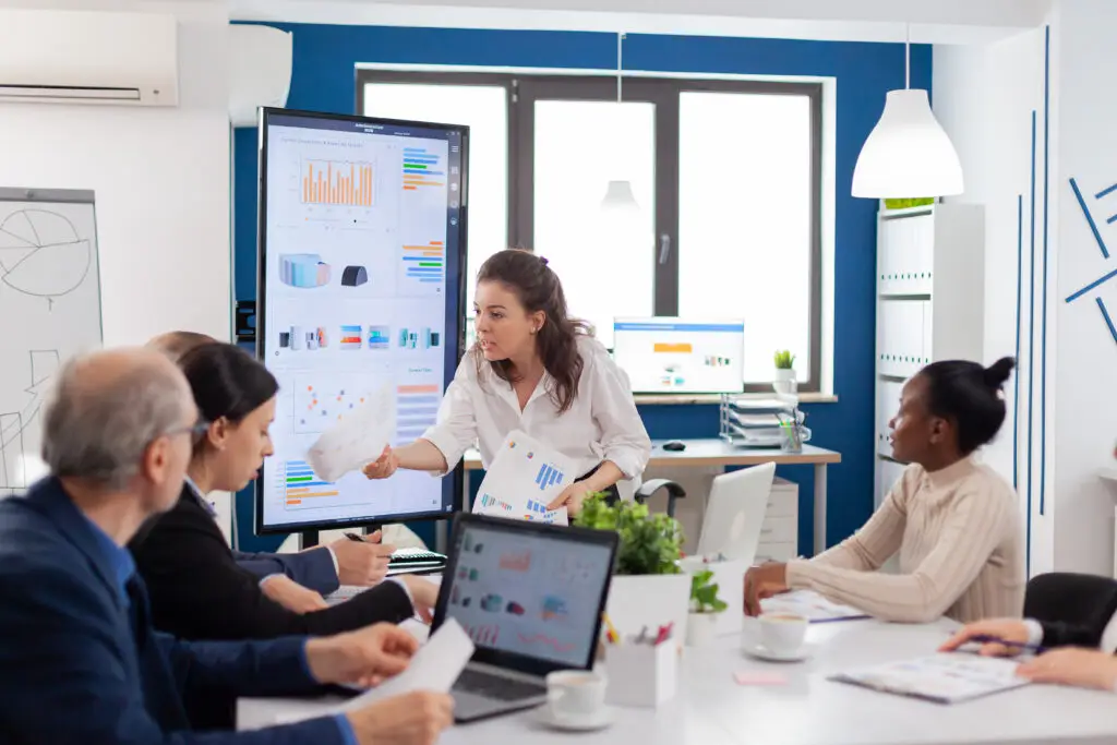furious company manager asking explications from multi ethnic coleagues holding finance report conference room